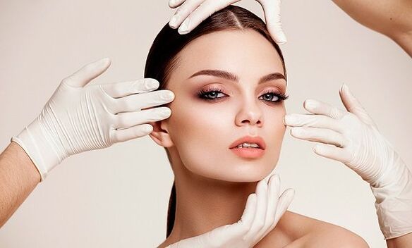 Hands with gloves on the girl's face